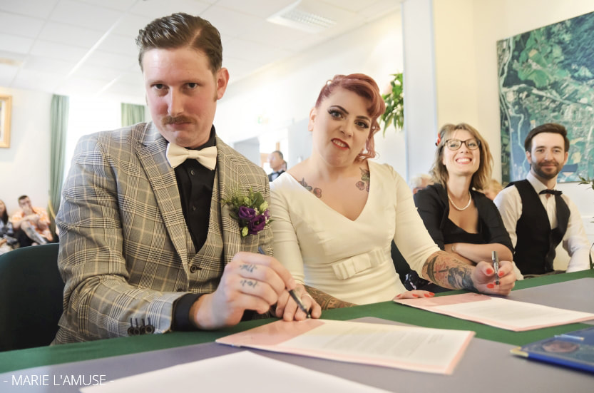 Idée d'élopement ou mariage intime : cérémonie civile d'un couple tatoué pendant la signature de l'acte de mariage par Marie l'Amuse photographe