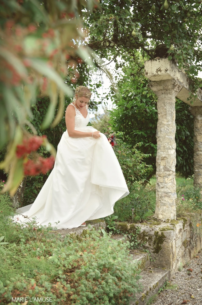 Mariage, Portrait, La mariée tient sa robe dans le parc du château, Avully Haute Savoie 2020, Photographe Marie l'Amuse
