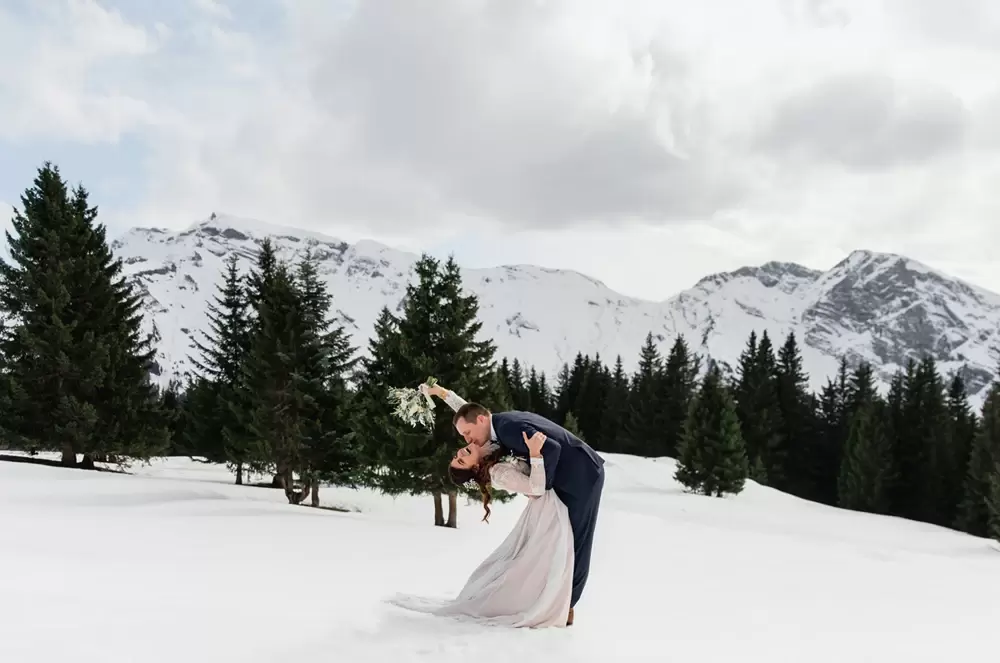 Le couple s'embrasse dans la neige en hiver lors de leur élopement à Avoriaz en Haute-Savoie