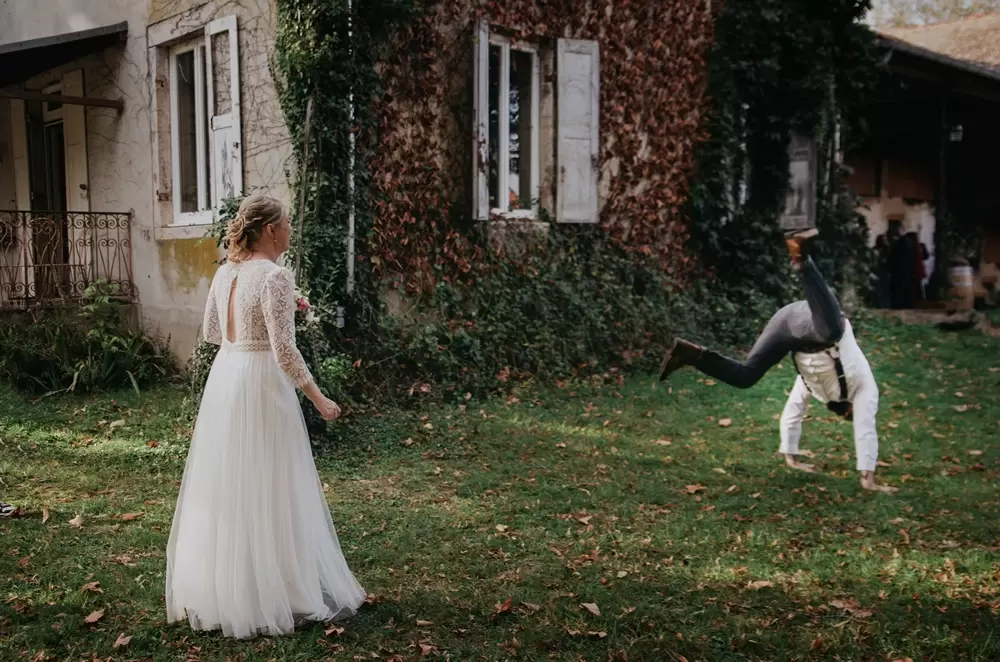 Mariage dans l'Ain, un homme fait une acrobatie devant la mariée dans le jardin du domaine de la Distillerie