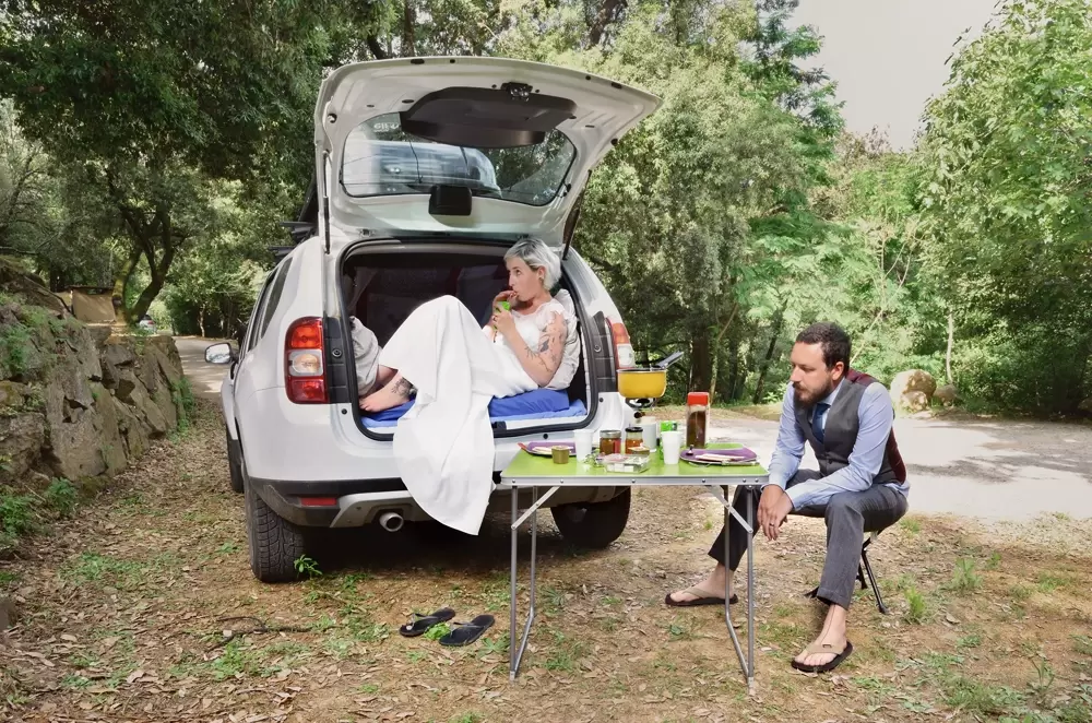 Mariage original d'un couple qui prend un petit déjeuner en extérieur en tenues de mariés dans une forêt Corse