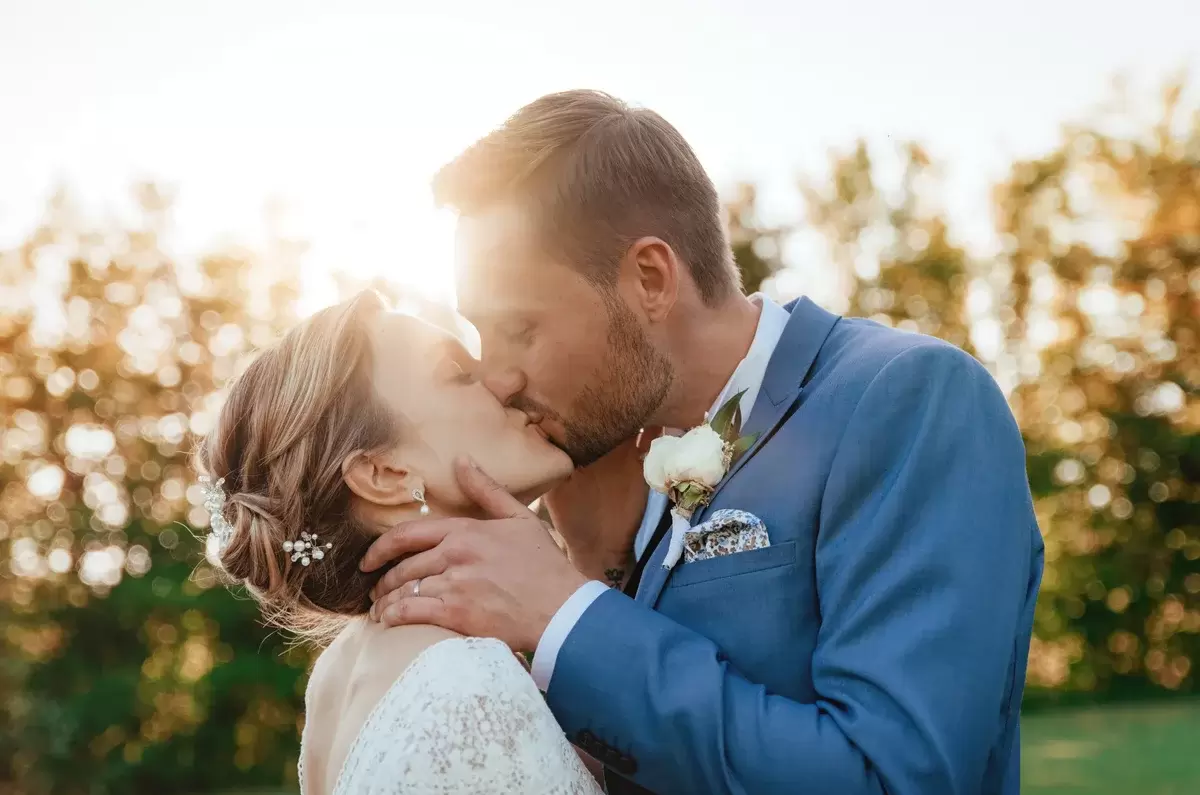 Un couple s'embrasse tendrement au coucher du soleil à la Grange à Jules pour leur elopement