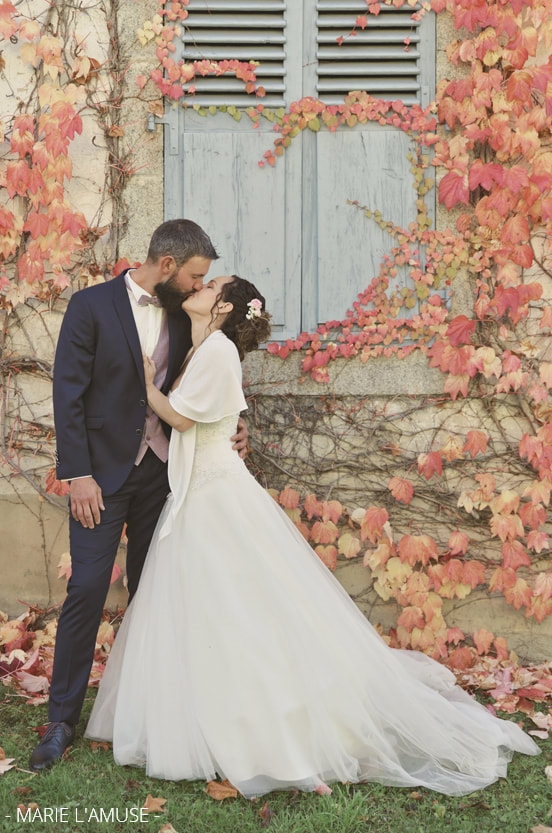 Mariage, Couple, Les futus époux s'embrassent devant un mur couvert de vigne rouge en automne, Vailly Haute Savoie -2019, Photographe Marie l'Amuse
