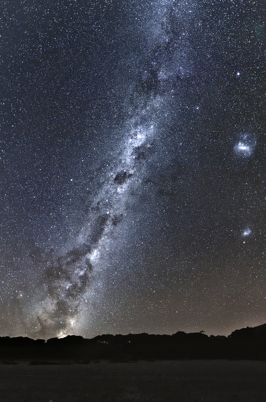 Ciel nocturne boréal : la Voie Lactée et les nuages de Magellan, côte ouest de la Nouvelle-Zélande.