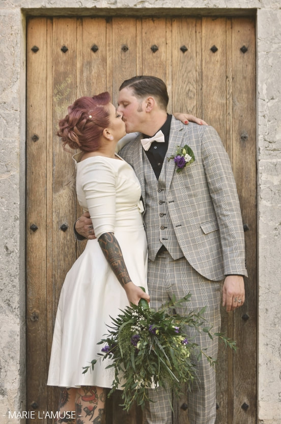 Mariage, Couple, Les mariés s'embrassent devant une porte en bois, Marignier Haute Savoie 2019, Photographe Marie l'Amuse
