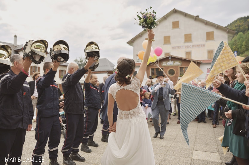 Mariage, Cérémonie, La mariée lève son bouquet lors de la sortie de la mairie, Bellevaux Haute Savoie-2019, Photographe Marie l'Amuse

