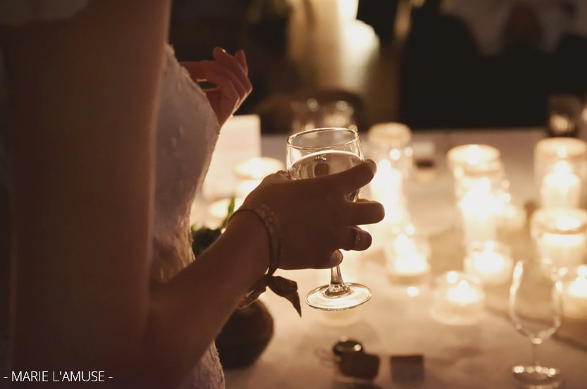 Mariage, Soirée, Détail de la mariée sui tient son verre devant des bougies, Mieussy Haute Savoie-2019, Photographe Marie l'Amuse
