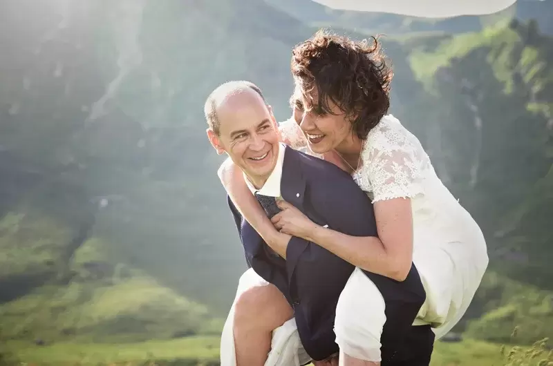 La mariée sur le dos du marié, rires lors de leur élopement à Taninges dans les Alpes
