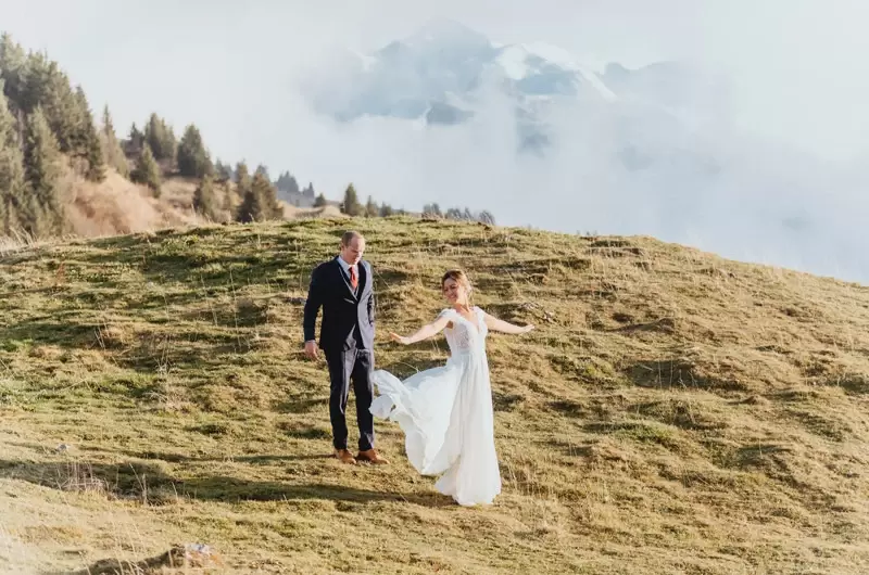 Un couple danse devant le Mont-Blanc en tenue de mariage pour leur elopement dans les Alpes

