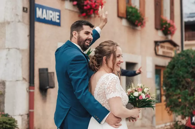Un couple fait signe aux invités lors de leur mariage à la mairie à Mégevette en Haute-Savoie
