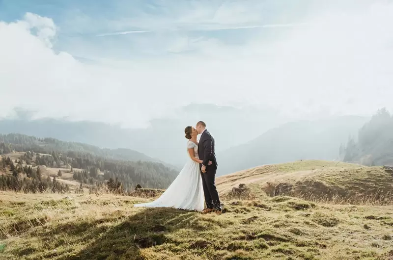 Mariage intime d'un couple qui s'embrasse devant un paysage de montagnes de Haute-Savoie à Samoëns
