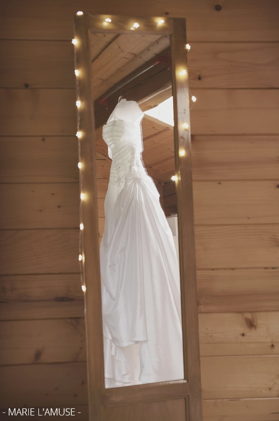 Reflet de la robe de mariée dans le miroir pendant les préparatifs. Mariage Bellevaux, Haute-Savoie.