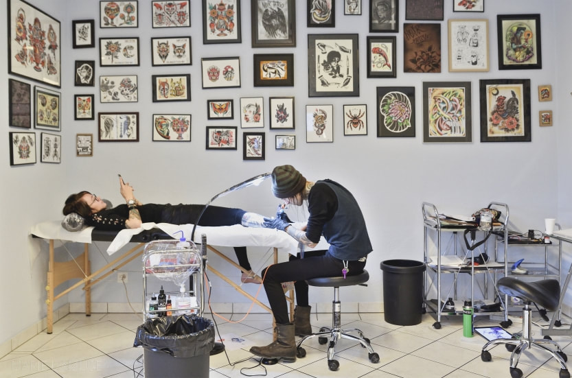 Reportage professionnel, entreprise, Grim Antihero de Noir Tattoo Fribourg dans le salon de tatouage, France, Photographe Marie l'Amuse
